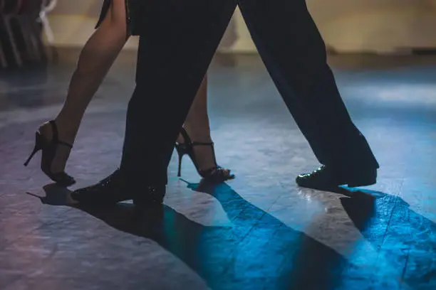 Dancing shoes of young couple, Couples dancing traditional latin argentinian dance milonga in the ballroom, tango salsa bachata kizomba lesson, dance festival, wooden floor, close view of shoes