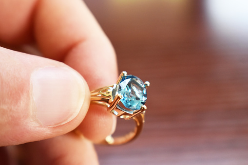 Precioso anillo de topacio azul de cerca en mano de alta calidad photo