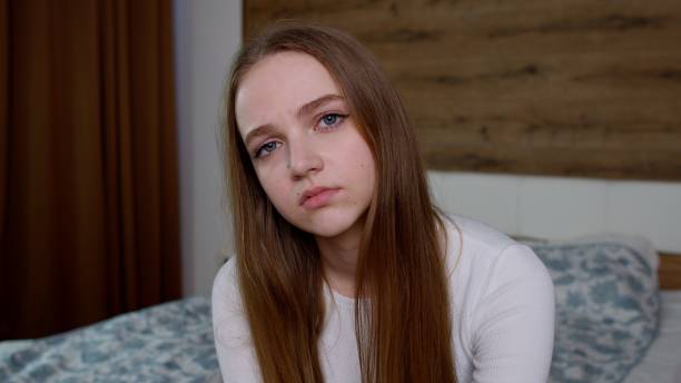 znudzona niezadowoszuła się dziewczyną zmęczoną wszystkim, patrzącą smutno z ponurą przygnębioną ekspresją w domu - teenager dark pensive emotional stress zdjęcia i obrazy z banku zdjęć