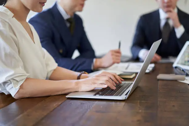 Photo of Asian female business woman recording meeting contents