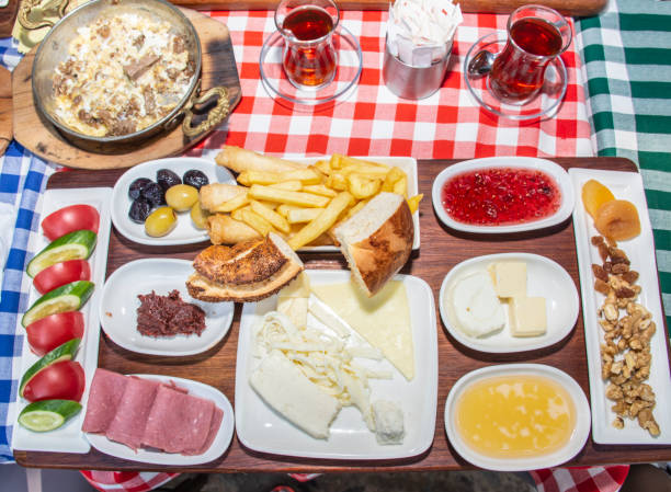 istock Family having delicious rich traditional Turkish breakfast include tomatoes, cucumbers, cheese, butter, eggs, honey, bread, olives, jam, sausage, fried potatoes and tea cups. 1307656276