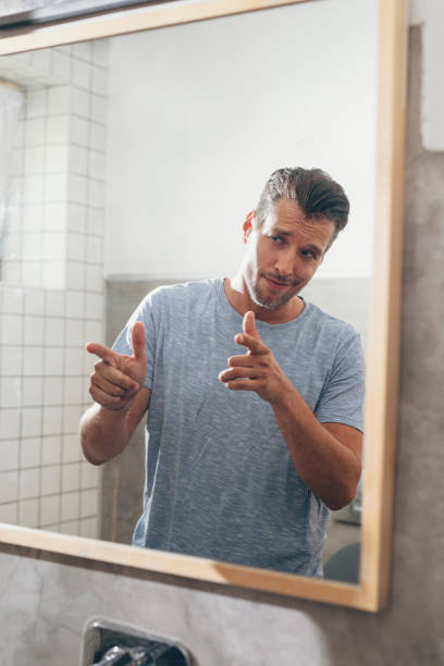 istock Handsome Young Man Checking his Beard in a Bathroom Mirror 1307656340