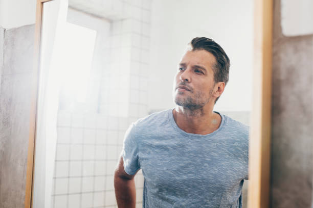 Handsome Young Man Checking his Beard in a Bathroom Mirror