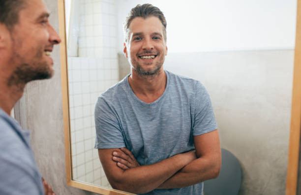 istock Handsome Young Man Checking his Beard in a Bathroom Mirror 1307656373