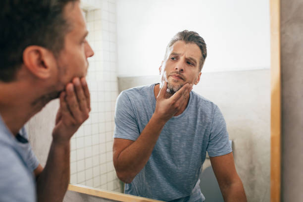 istock Handsome Young Man Checking his Beard in a Bathroom Mirror 1307656375