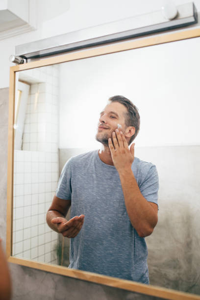 istock Handsome Young Man Applying Face Cream Early in the Morning 1307656385