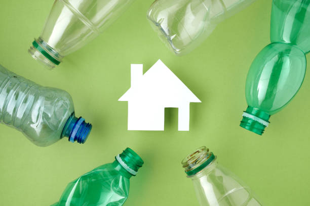 istock flat lay with plastic bottles and house isolated on green 1307657988