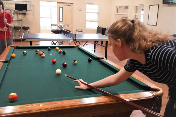 девочка-подросток стреляет бассейн (бильярд) - child sport playing pool game стоковые фото и изображения