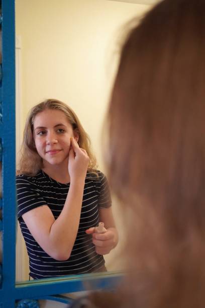 istock Teen Girl Puts on Cream (Cosmetics), Copy Space 1307666708