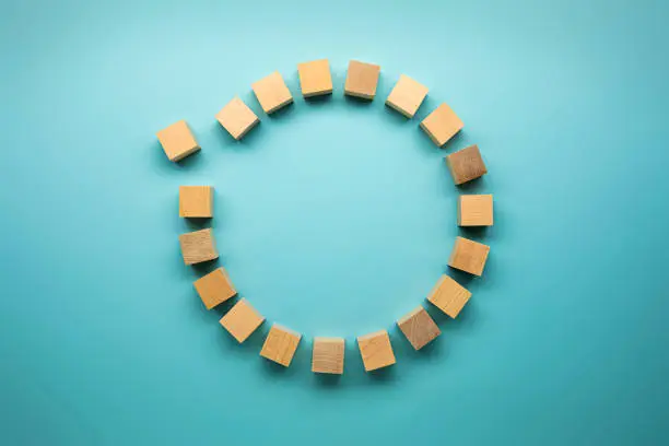 Photo of Blocks made out of wood in a circle on blue background