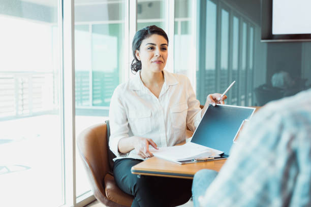 le propriétaire féminin confiant d’affaires écoute l’homme - porte documents photos et images de collection