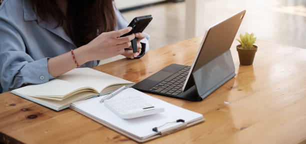 Closeup business woman using smartphone and checking meeting schedule ,Work From Home concept. Closeup business woman using smartphone and checking meeting schedule ,Work From Home concept smart phone telephone research tax stock pictures, royalty-free photos & images