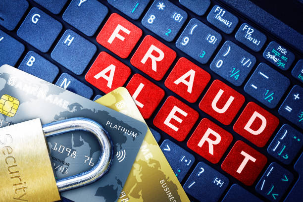 Fraud Alert Concept With Security Lock on Fake Credit Cards Fraud Alert in red keys on high-tech computer keyboard background with security engraved lock on fake credit cards. Concept of Internet security, data privacy, cybercrime prevention for online shopping transaction payments. cyber crime prevention stock pictures, royalty-free photos & images