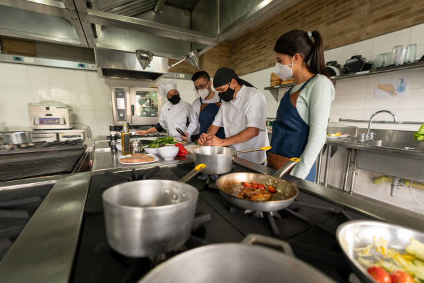 istock Group of people wearing facemasks in a cooking class 1307676690