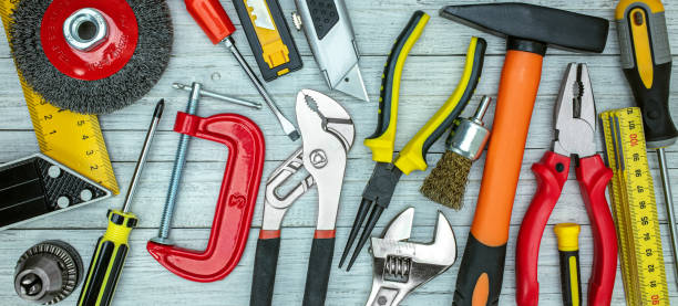istock various working tools on grey table background. drills, wrenches, bolts, screws, clamps top view 1307677541