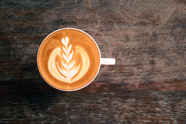 istock Cup of latte art coffee on wooden table 1307677564