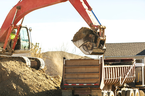 Front view of heavy duty yellow color excavator with shovel at sunny day.