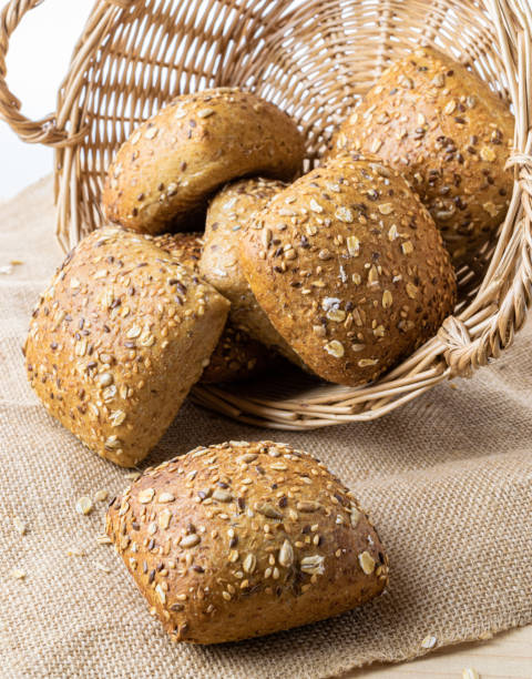 istock Rustic rye. Fresh loaf of rustic traditional bread with wheat grain ear or spike plant on linen texture background. Bakery with crusty loaves and crumbs. Design element for bakery product label. 1307683091