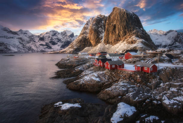 Evening view of famous tourist attraction Hamnoy fishing village on Lofoten Islands, Norway with red rorbu houses in winter Evening view of famous tourist attraction Hamnoy fishing village on Lofoten Islands, Norway with red rorbu houses in winter reine lofoten stock pictures, royalty-free photos & images