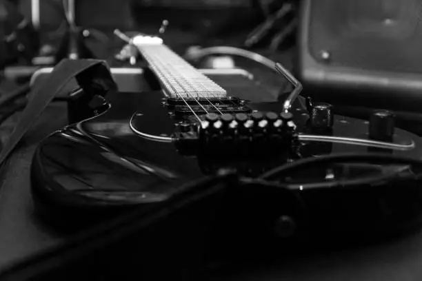 Photo of Black electric guitar with tremolo on a hard case