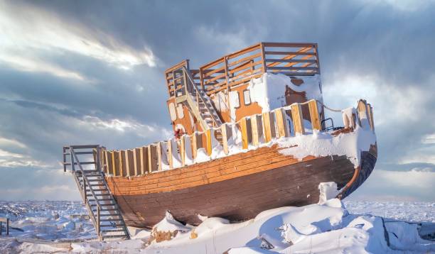 An old wooden boat on dry land in winter, now a landmark in a public park in Churchill, Manitoba, Canada. A wooden boat hauled out of the water and turned into a tourist attraction on the snowy Hudson Bay shore. manitoba photos stock pictures, royalty-free photos & images