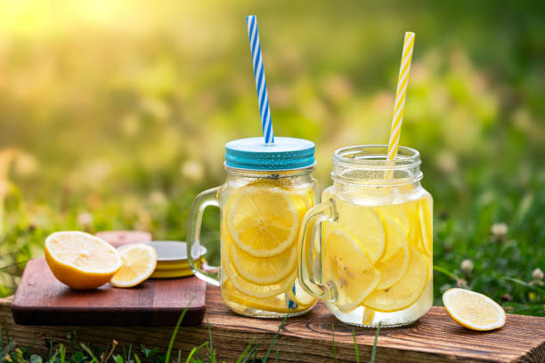 refreshing cold lemonade in a jar on a sunny meadow stock photo