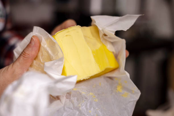 istock hand holding a bulk of butter 1307694298