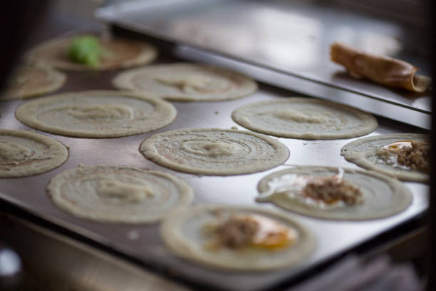 cooking rolling pancake (Khanom Tokyo) thin flat pancake filled with sweet custard cream - Thai street snack