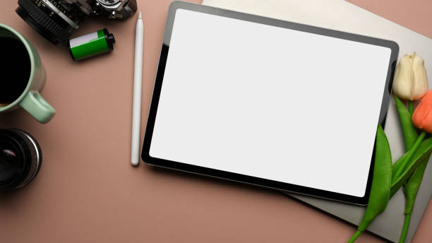 istock Pink creative workspace with digital tablet, laptop, tulip flower, camera and coffee cup 1307696895