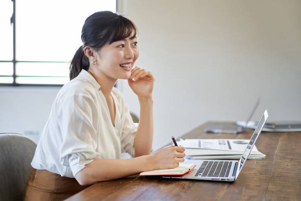 istock Asian woman working on a computer with a smile on telework 1307698748