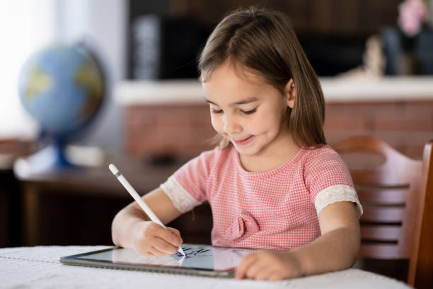 istock Little Child Girl Drawing On Digital Tablet Using Digitized Pen 1307700008
