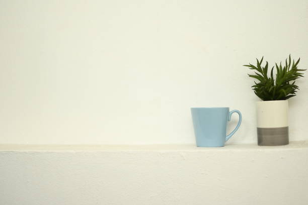istock plant in a vase and blue glass put on white wall background 1307700824