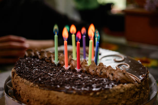 istock Chocolate birthday cake with candles, lighting candles on the cake. 1307701014