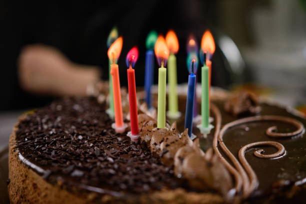 istock Chocolate birthday cake with candles, lighting candles on the cake. 1307701020