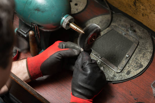 istock man wearing protective gloves polishes a silver ring with a grinder 1307701798