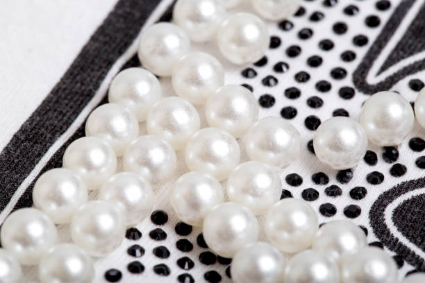 hermosa decoración de perlas en forma de bolas blancas en ropa elegante, macro - pearl necklace earring jewelry fotografías e imágenes de stock