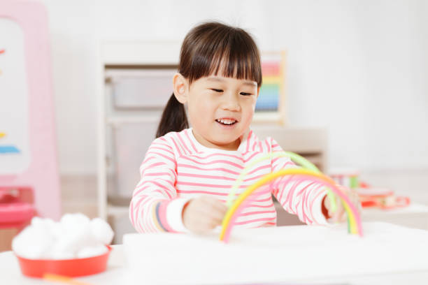 istock Young Girl Making Rainbow Craft Using Pipe Cleaner At Home 1307702360