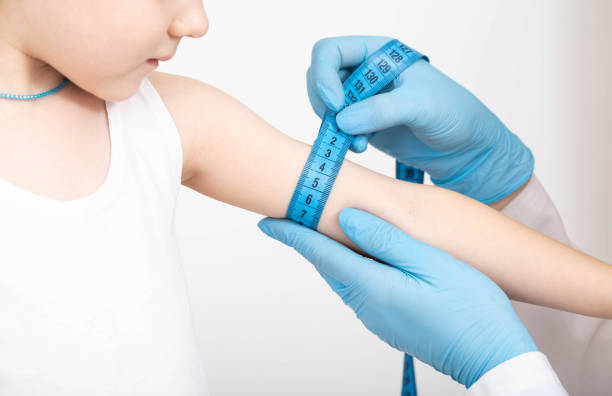 Doctor nutritionist measures the thickness of the child's hand with a measuring tape. The concept of being too thin, underweight, close-up. Doctor nutritionist measures the thickness of the child's hand with a measuring tape. The concept of being too thin, underweight, close-up. Girl aged 4 too thin stock pictures, royalty-free photos & images