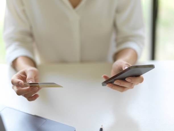 istock Female hand using smartphone and holding credit card 1307703821