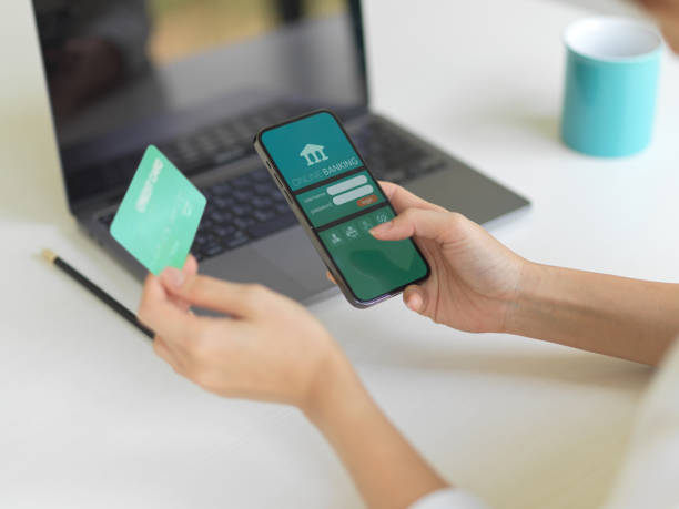 istock Female hand using online banking application on smartphone and holding credit card 1307703839