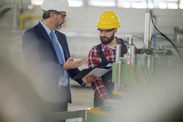 istock Young engineer with quality control inspector in factory stock photo 1307705552