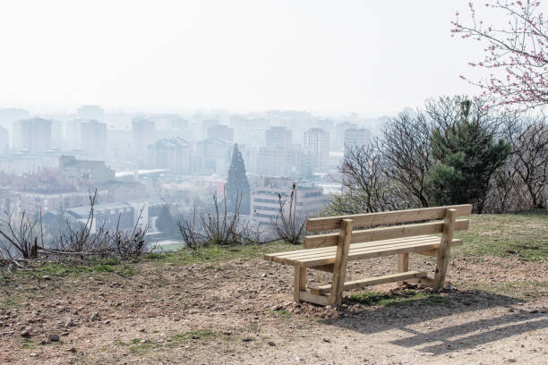 istock empty wooden bench in spring park over the city 1307706768