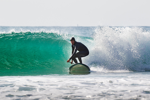 Surf Sup, Stand Up Paddle Boarding on a wave in Japan, a man is riding in the Pacific Ocean in Chiba. Its an extreme sport.