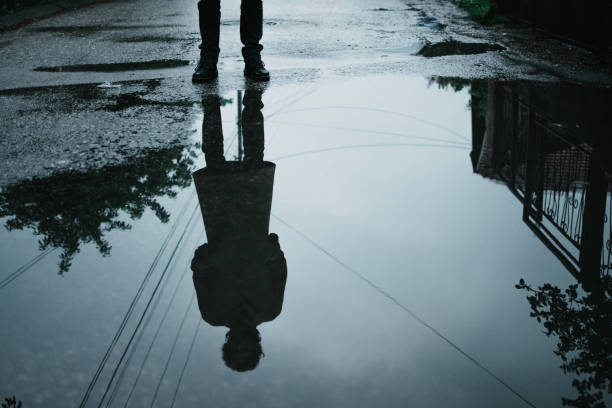 istock Reflection of an unknown man in a puddle 1307711108