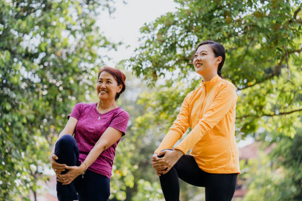 istock Asian mother and daughter doing relaxation exercise at public park 1307712533