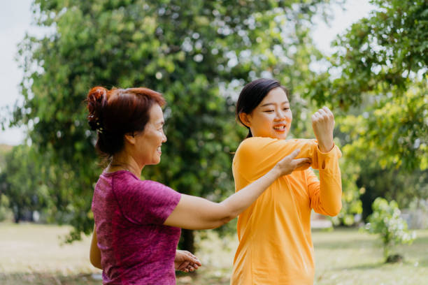 istock Asian mother and daughter doing relaxation exercise at public park 1307712574