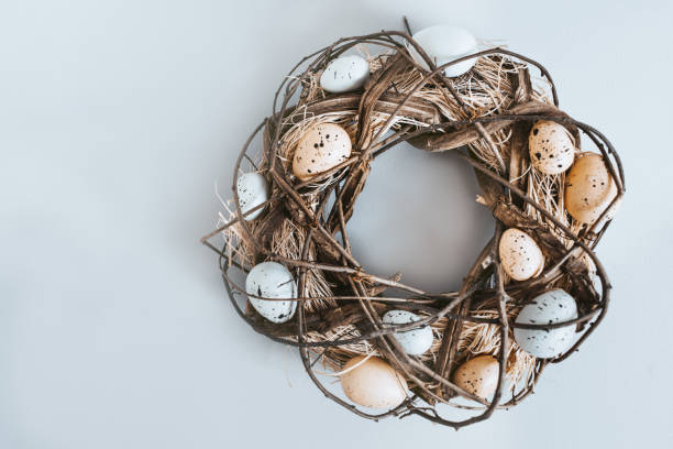 istock Easter door wreath decorated with eggs and woven twigs on white background. 1307712852