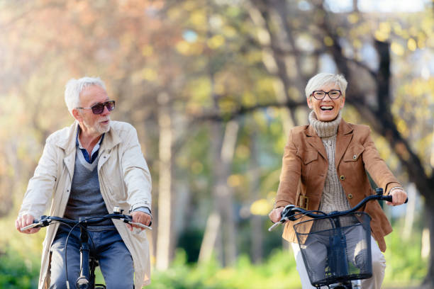 istock Cheerful active senior couple with bicycle in public park together having fun 1307712877