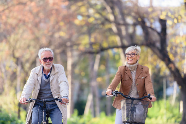 istock Cheerful active senior couple with bicycle in public park together having fun 1307712997