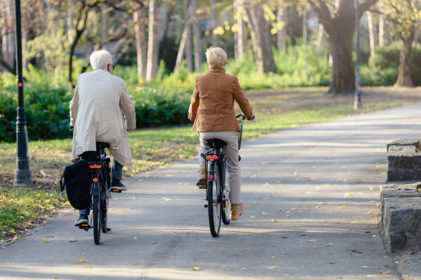 istock Cheerful active senior couple with bicycle in public park together having fun 1307713775